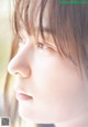 A close up of a woman's face looking out a window.