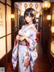 A woman in a kimono standing in a hallway.