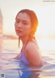 A woman in a purple bathing suit in the water.