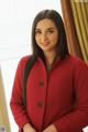 A woman in a red coat posing for a picture.