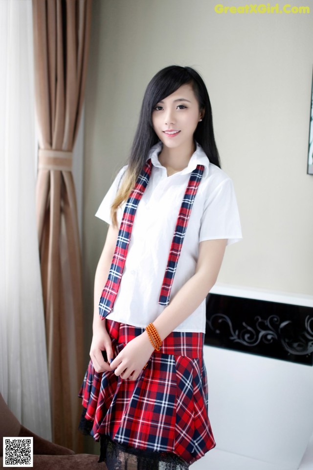 A woman in a school uniform posing for a picture.